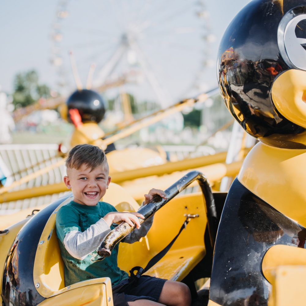 A child smiling on an amusement park ride